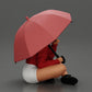 Diorama Modellbau Produktfoto 1: Diorama-Miniatur: Sitzende Frau in Jacke und Shorts mit offenem Regenschirm (Ref Nr. A85)