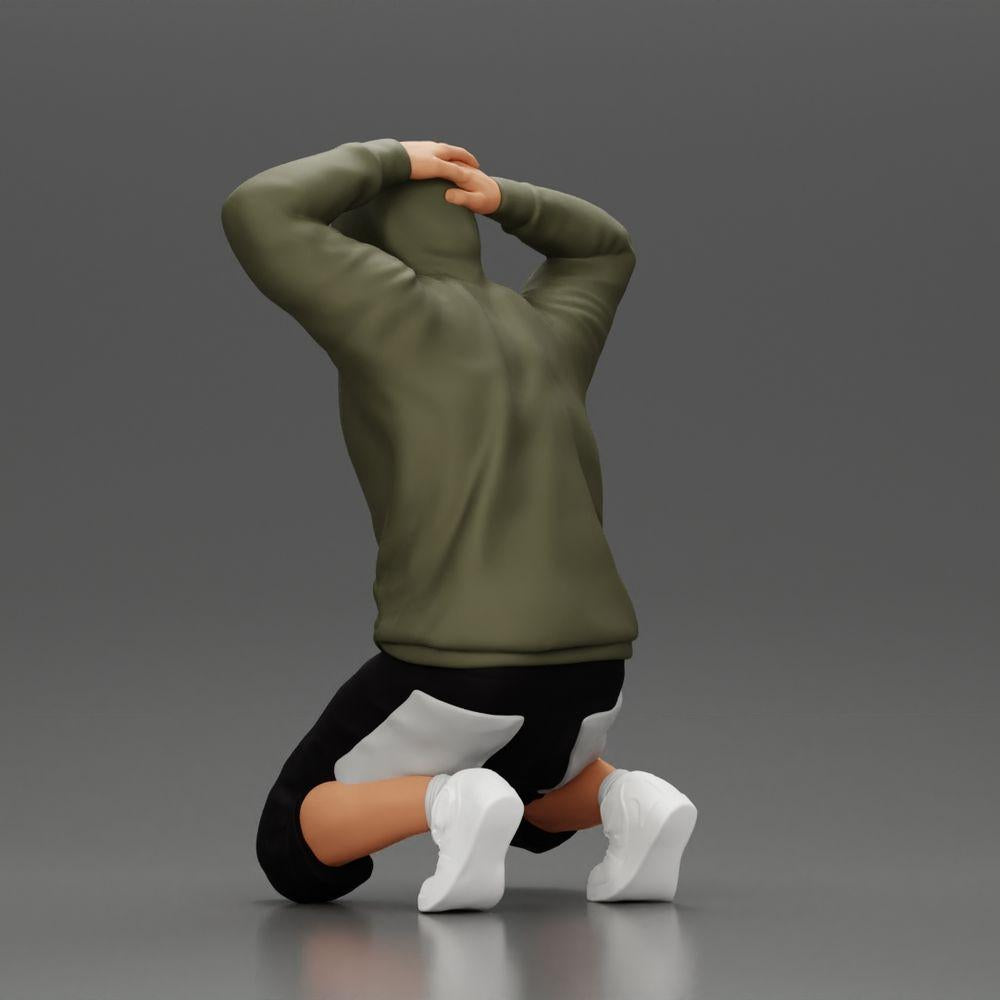 Diorama Modellbau Produktfoto 3: Kniender Mann mit Kapuzenpullover, Hände hinter dem Kopf - Diorama Miniatur (Ref Nr. A70)